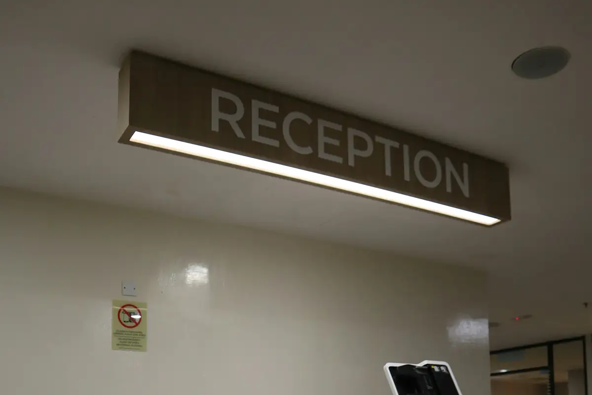 Reception desk under a reception sign in a clinic waiting area